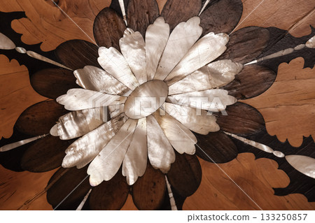 Close-up of an intricate floral parquet inlay featuring pearl petals 133250857