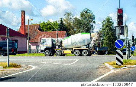 Heavy duty concrete mixer truck at road intersection, industry. Copy space for text Heavy duty concrete mixer truck at road intersection, industry. Copy space for text 133250947