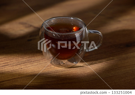 Discovering the warmth of a steaming cup of tea on a rustic wooden table in a peaceful moment 133251004