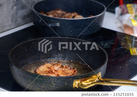 Cooking succulent pork chops in a modern kitchen with sizzling sounds filling the air 133251035