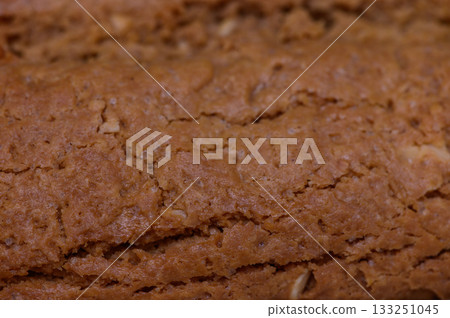 Deliciously baked homemade bread with a golden crust, cooling on a wooden kitchen counter 133251045