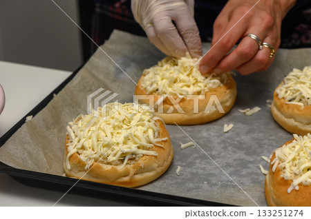 Cheesy rolls being prepared with care in a cozy kitchen setting 133251274