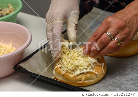 Delicious preparation of a savory sandwich with fresh toppings in a cozy kitchen setting Delicious preparation of a savory sandwich with fresh toppings in a cozy kitchen setting 133251277