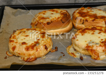 Melting cheese and savory toppings create a mouthwatering delight in an oven-baked dish 133251278