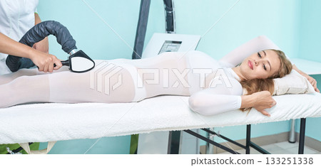 Young caucasian female undergoing body contouring procedure in medical spa Young caucasian female undergoing body contouring procedure in medical spa 133251338