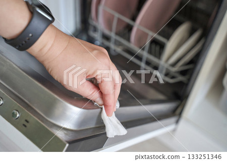 Female hand cleaning dishwasher with wipe in kitchen interior hygiene chores Female hand cleaning dishwasher with wipe in kitchen interior hygiene chores 133251346