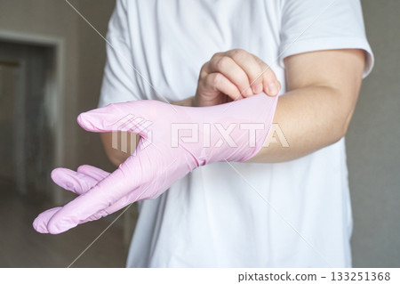 Caucasian adult wearing pink gloves for hygiene and safety in a clean Caucasian adult wearing pink gloves for hygiene and safety in a clean 133251368