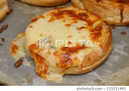 Melting cheese on warm buns creates a delightful savory treat in a cozy kitchen 133251465