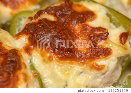Cheese-topped stuffed bell peppers baked to golden perfection during a cozy evening gathering Cheese-topped stuffed bell peppers baked to golden perfection during a cozy evening gathering 133251539