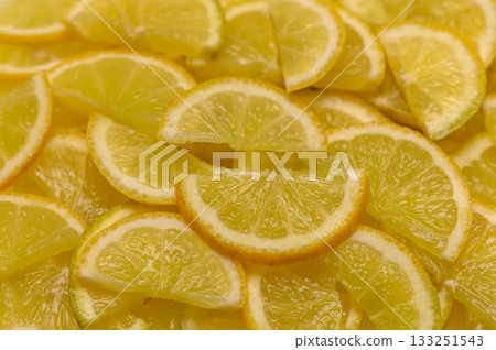 Slices of vibrant lemons arranged beautifully on a bright surface in a sunny kitchen setting Slices of vibrant lemons arranged beautifully on a bright surface in a sunny kitchen setting 133251543