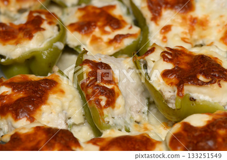 Creamy stuffed peppers bake to golden perfection in a cozy kitchen filled with savory aromas 133251549
