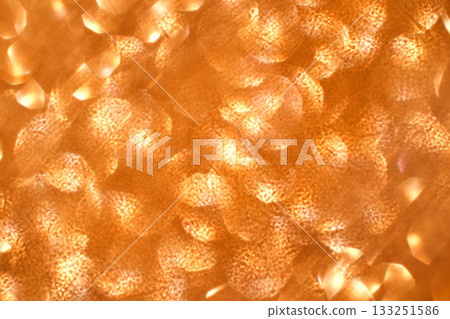Abstract pattern of orange and gold light reflections creating a warm 133251586