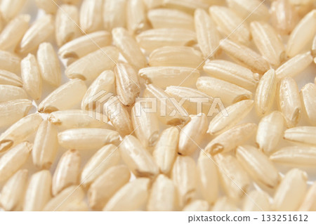 Close up of uncooked brown rice grains showing texture and detail 133251612