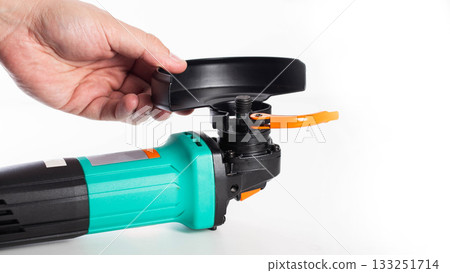 Installing the protective cover on a new grinder before use. Safety precautions, white background, isolated. Copy space for text, close-up Installing the protective cover on a new grinder before use. Safety precautions, white background, isolated. Copy space for text, close-up 133251714