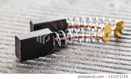 New brushes for replacement in an electric motor on a gray background, close-up, industry 133251724