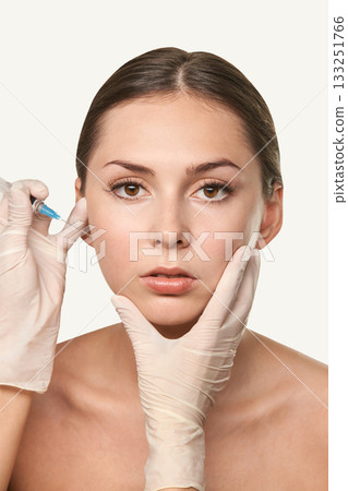Young caucasian female receiving cosmetic injection treatment by dermatologist 133251766