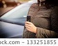 Woman Holding Digital Breathalyzer Before Driving. Responsible Driver Checks Alcohol Level. Copy space for text. Driving license revocation for alcohol 133251855