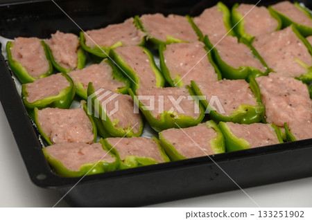Savory preparation of stuffed green peppers ready for baking in a cozy kitchen setting Savory preparation of stuffed green peppers ready for baking in a cozy kitchen setting 133251902