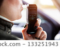 Female Driver Exhaling Into Digital Alcohol Analyzer. Woman Performing Sobriety Self-Test. 133251943