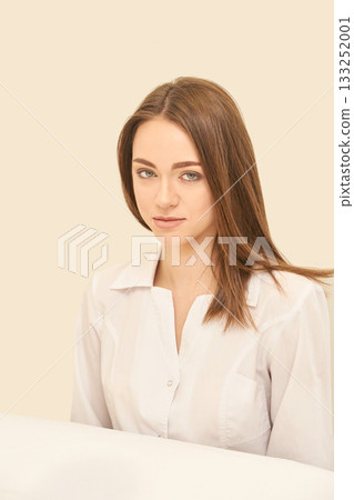 Young caucasian female in white shirt posing against neutral background 133252001