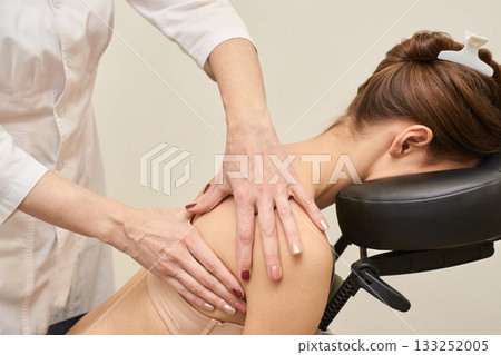 Female caucasian adult receiving shoulder massage in relaxing spa setting Female caucasian adult receiving shoulder massage in relaxing spa setting 133252005