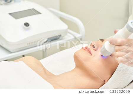 Female caucasian adult receiving facial treatment with modern skin care 133252009