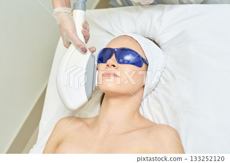 Young caucasian female undergoing laser skin treatment with protective eyewear Young caucasian female undergoing laser skin treatment with protective eyewear 133252120