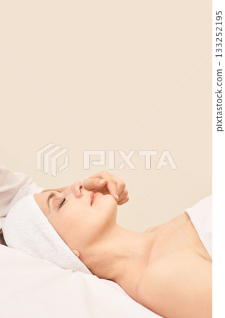 Young caucasian female enjoying a relaxing spa treatment with soft neutral Young caucasian female enjoying a relaxing spa treatment with soft neutral 133252195