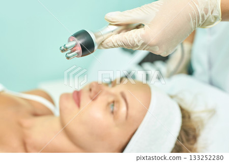 Caucasian young female receiving radiofrequency facial treatment in spa clinic Caucasian young female receiving radiofrequency facial treatment in spa clinic 133252280