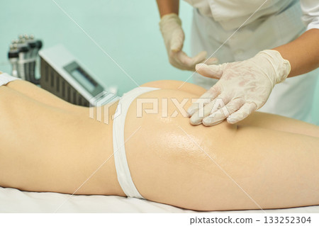 Female spa treatment: professional body care with massage and moisturizing 133252304