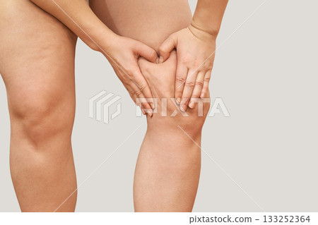 Female adult caucasian massaging thigh with hands for cellulite control Female adult caucasian massaging thigh with hands for cellulite control 133252364