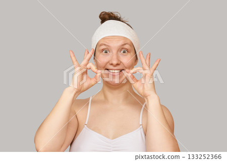 Caucasian female performing facial exercises for fitness and skin care routine Caucasian female performing facial exercises for fitness and skin care routine 133252366