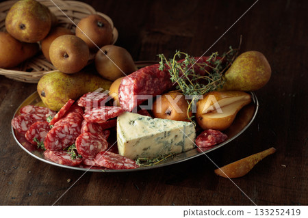 Dry-cured sausages, blue cheese, thyme and pears. 133252419