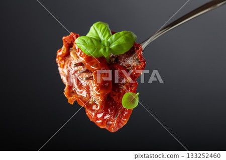 Sun dried tomatoes in olive oil with green basil. 133252460