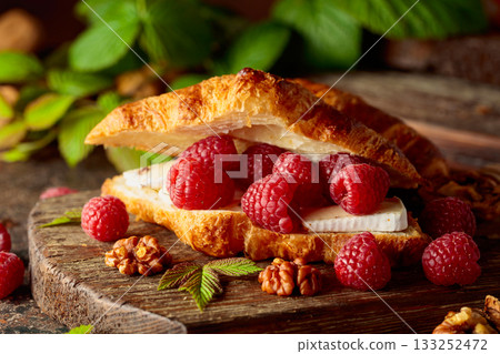 Croissant with camembert cheese, raspberries and walnuts. Croissant with camembert cheese, raspberries and walnuts. 133252472
