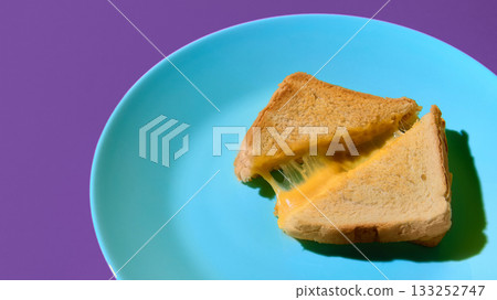 Cheese toast sandwich melting on turquoise plate with purple background 133252747
