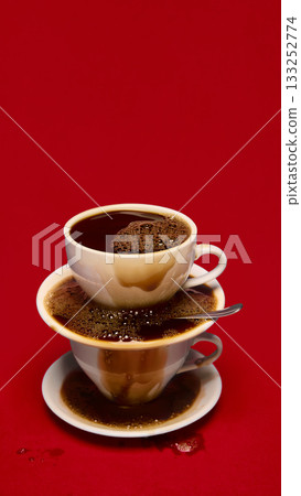 Overflowing stacked coffee cups on bold red background Overflowing stacked coffee cups on bold red background 133252774