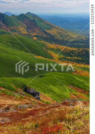 A panoramic view of the mountains dyed in autumn leaves from the Furanodake hiking trail (Hokkaido) A panoramic view of the mountains dyed in autumn leaves from the Furanodake hiking trail (Hokkaido) 133253434