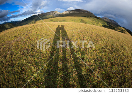 Photographer taking photo on high altitude grassland mountain top 133253583