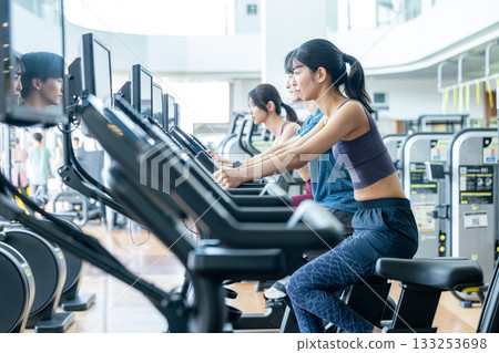在健身房使用直立式自行車的男男女女 133253698