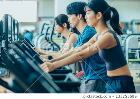 在健身房使用直立式自行車的男男女女 133253699