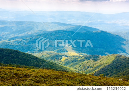 mountain landscape with rolling hills. summer countryside scenery of ukraine with view in to the distant valley and green forested slopes on a sunny forenoon. background for hiking and eco tourism mountain landscape with rolling hills. summer countryside scenery of ukraine with view in to the distant valley and green forested slopes on a sunny forenoon. background for hiking and eco tourism 133254022