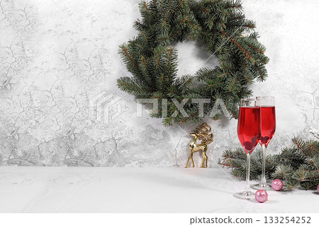 Christmas alcoholic cocktail with red champagne "Mimosa" with cranberry in glasses on a festive background with fir branches and decorations, bar and Christmas Eve concept, alcoholic drinks at a party 133254252