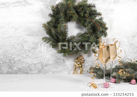 Happy New Year. Two glasses of champagne against a festive backdrop of fir branches and decorations, a Christmas Eve concept. Christmas and New Year's mockup for product design and sales Happy New Year. Two glasses of champagne against a festive backdrop of fir branches and decorations, a Christmas Eve concept. Christmas and New Year's mockup for product design and sales 133254253