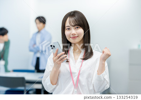 有一部智能手機的女商人在辦公室 有一部智能手機的女商人在辦公室 133254319