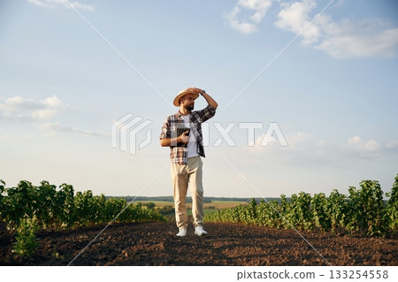 View from the front of him. Farmer is on the agricultural field View from the front of him. Farmer is on the agricultural field 133254558