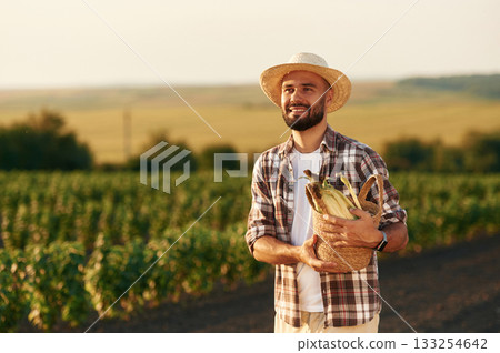 Corn in package. Farmer is on the agricultural field 133254642