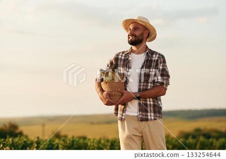 Corn in package. Farmer is on the agricultural field 133254644