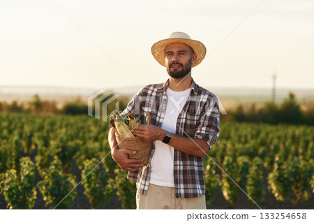 Finished product. Corn in hands. Farmer is on the agricultural field 133254658