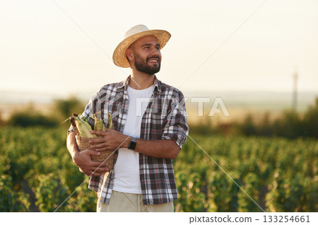 Finished product. Corn in hands. Farmer is on the agricultural field 133254661